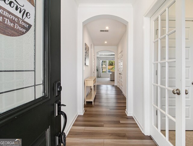 corridor featuring hardwood / wood-style flooring and ornamental molding