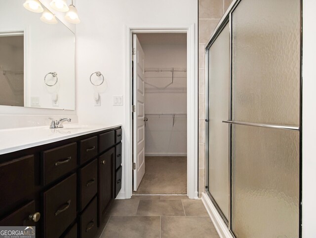 bathroom featuring walk in shower, vanity, and tile patterned flooring