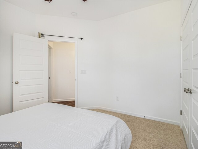 carpeted bedroom featuring a barn door