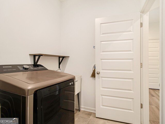 laundry area with washer / dryer and light tile patterned floors