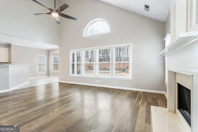 unfurnished living room featuring a premium fireplace, high vaulted ceiling, hardwood / wood-style floors, and ceiling fan