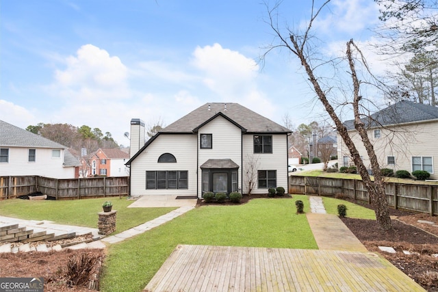 rear view of house with a wooden deck and a lawn