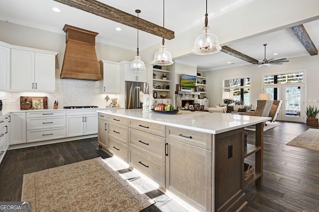 kitchen featuring white cabinetry, premium range hood, a center island, and high end fridge