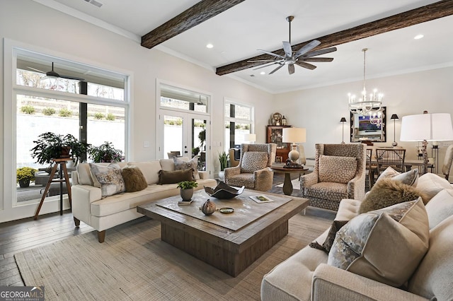 living room with hardwood / wood-style floors, beam ceiling, ornamental molding, ceiling fan with notable chandelier, and french doors