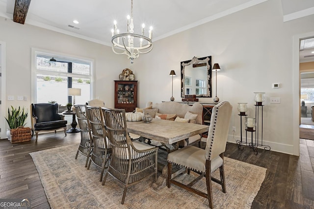 dining area with an inviting chandelier, ornamental molding, and dark hardwood / wood-style flooring