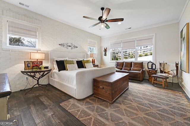 bedroom with crown molding, dark wood-type flooring, ceiling fan, and brick wall