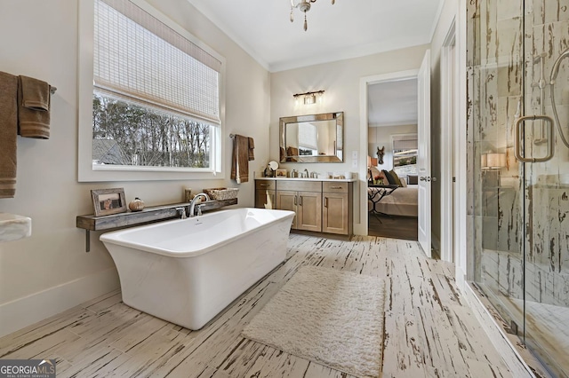 bathroom featuring ornamental molding, separate shower and tub, hardwood / wood-style floors, and vanity