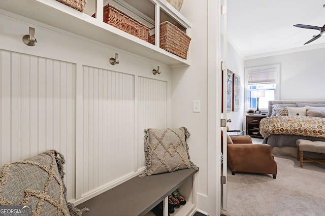 mudroom featuring carpet floors, ornamental molding, and ceiling fan