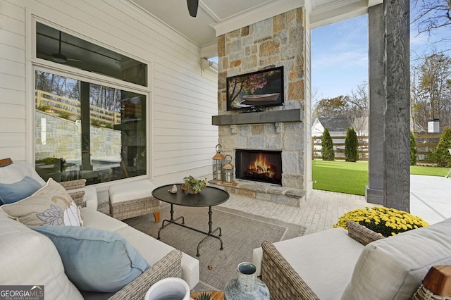 view of patio / terrace with an outdoor living space with a fireplace and ceiling fan