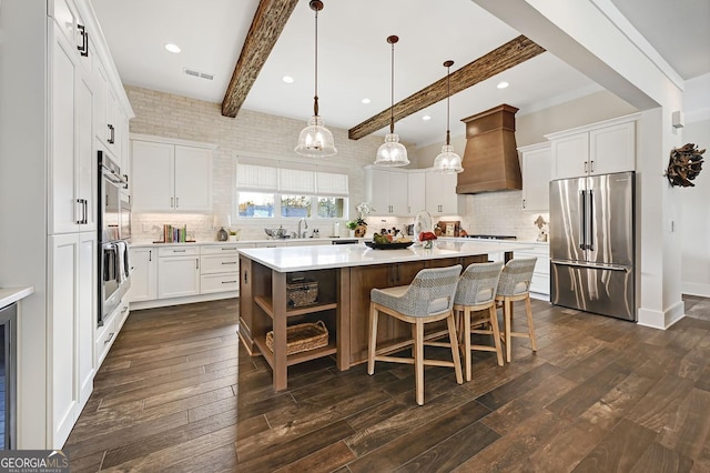 kitchen with a kitchen island, decorative light fixtures, white cabinets, custom exhaust hood, and stainless steel appliances