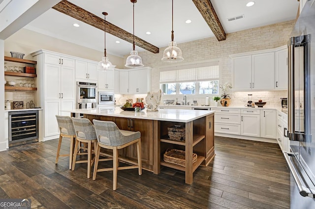 kitchen featuring white cabinets, a kitchen island, and wine cooler