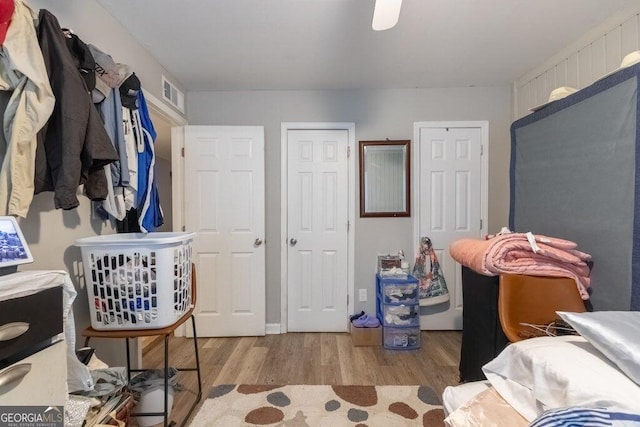 bedroom with multiple closets and light hardwood / wood-style floors