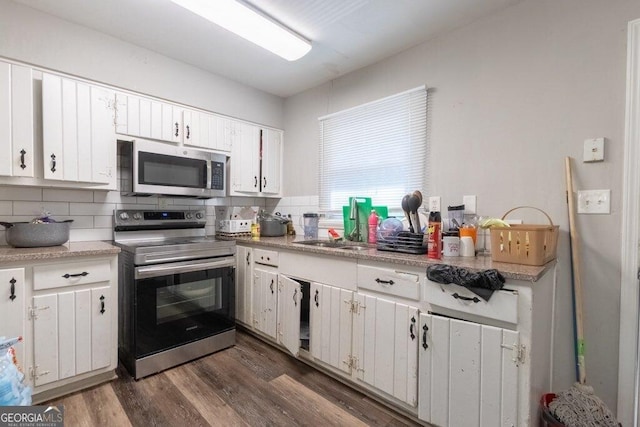 kitchen featuring white cabinetry, sink, dark hardwood / wood-style flooring, decorative backsplash, and stainless steel appliances