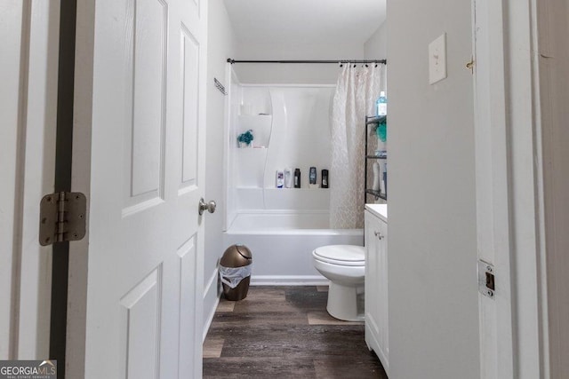 full bathroom with hardwood / wood-style flooring, vanity, shower / tub combo, and toilet