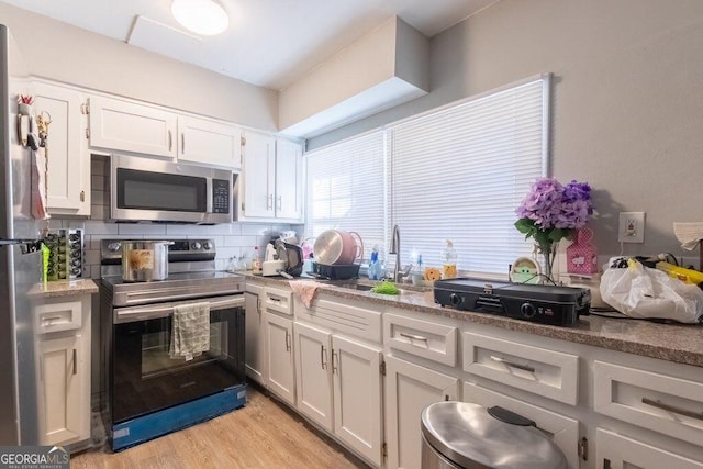 kitchen with white cabinetry, sink, light hardwood / wood-style flooring, and stainless steel appliances