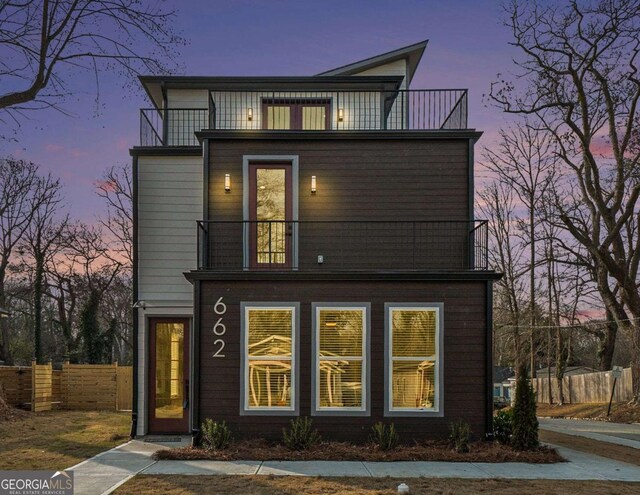 back house at dusk with a balcony