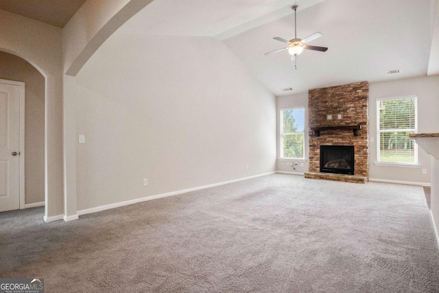 unfurnished living room featuring a stone fireplace, high vaulted ceiling, ceiling fan, and carpet flooring