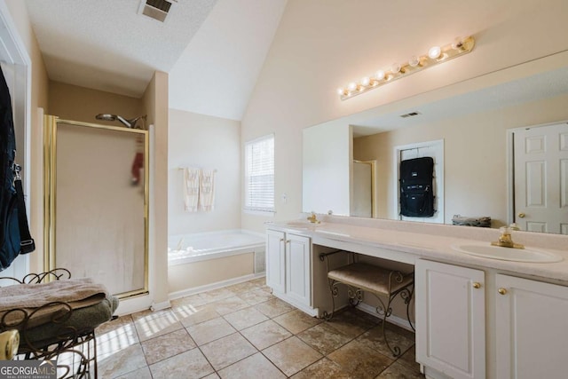 bathroom with independent shower and bath, vaulted ceiling, tile patterned flooring, and vanity