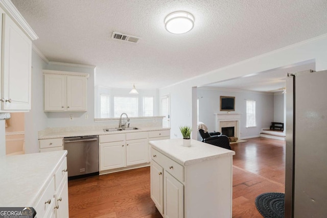 kitchen with hardwood / wood-style floors, sink, a center island, stainless steel appliances, and crown molding