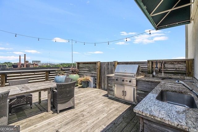 wooden terrace featuring area for grilling and sink