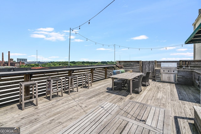 wooden terrace with grilling area and exterior kitchen