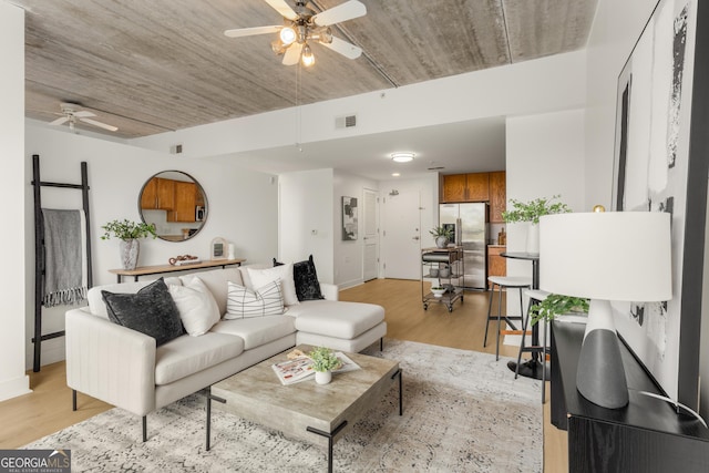 living room featuring ceiling fan and light hardwood / wood-style flooring