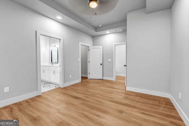 unfurnished bedroom featuring connected bathroom and light hardwood / wood-style floors