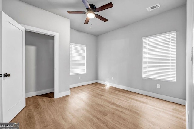 unfurnished bedroom with multiple windows, ceiling fan, and light hardwood / wood-style flooring