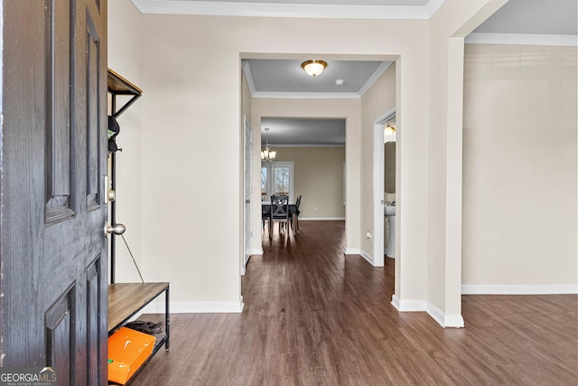 entryway with a notable chandelier, crown molding, and dark hardwood / wood-style floors