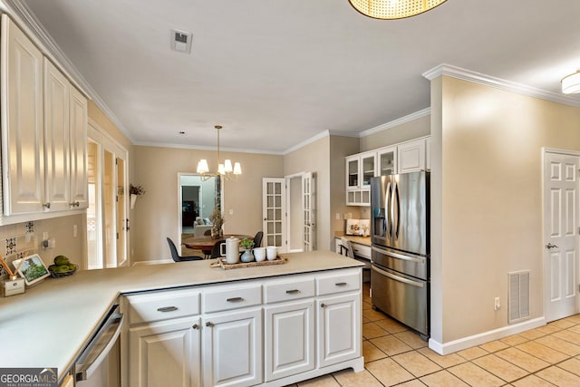 kitchen with hanging light fixtures, light tile patterned floors, appliances with stainless steel finishes, kitchen peninsula, and white cabinets