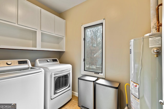 washroom with cabinets, gas water heater, light tile patterned flooring, and independent washer and dryer