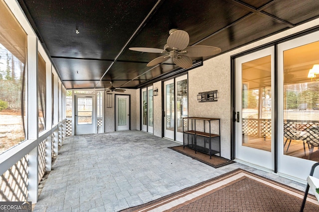 unfurnished sunroom with ceiling fan