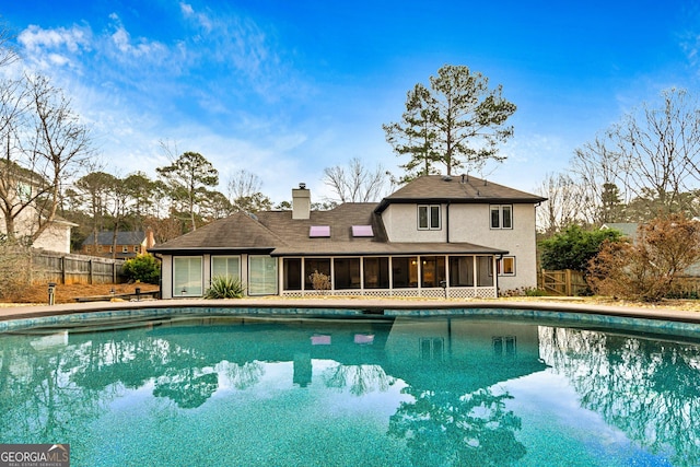 view of swimming pool featuring a sunroom