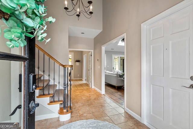 tiled foyer with an inviting chandelier and a towering ceiling