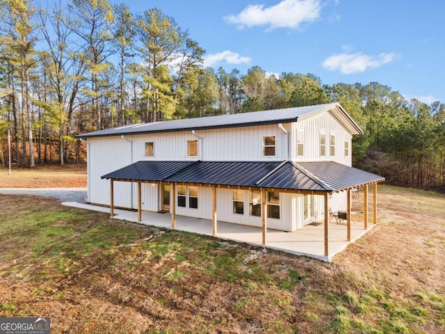 rear view of property featuring a patio and a lawn