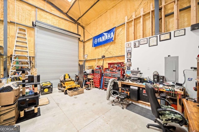 garage featuring electric panel and a workshop area