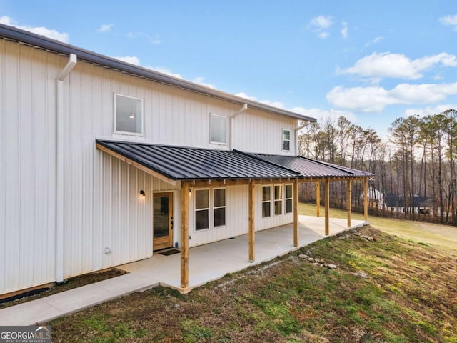 back of house with a lawn and a patio