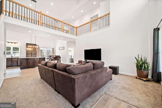 carpeted living room featuring a high ceiling