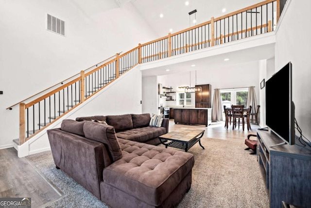 living room featuring a towering ceiling and light wood-type flooring