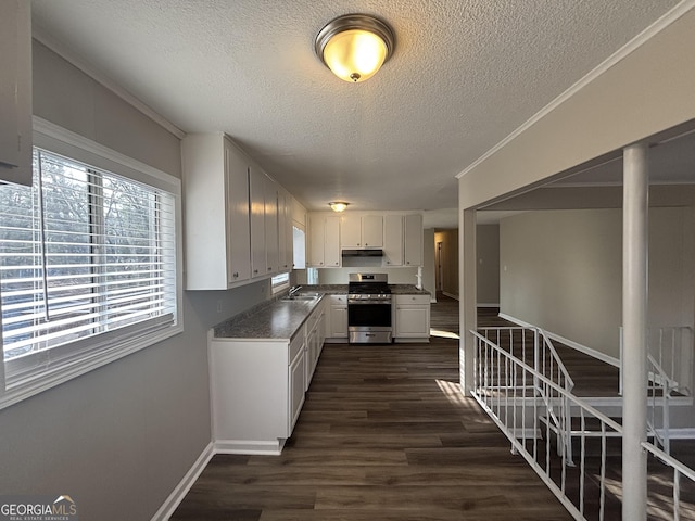 kitchen featuring sink, stainless steel gas stove, white cabinetry, a textured ceiling, and dark hardwood / wood-style flooring