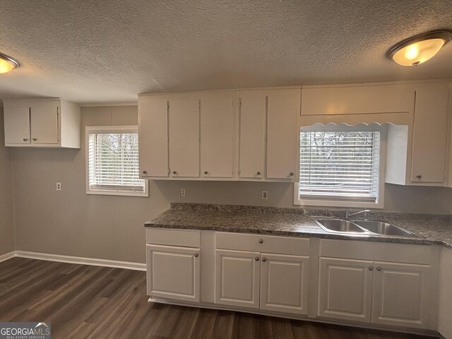 kitchen with dark hardwood / wood-style flooring, sink, a textured ceiling, and white cabinets