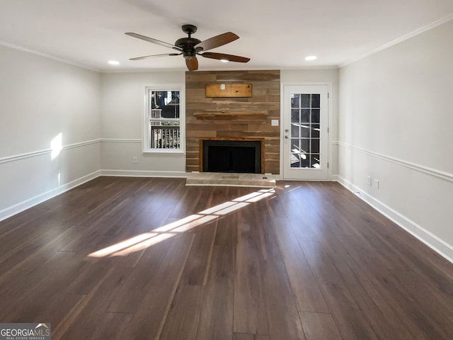 unfurnished living room featuring crown molding, ceiling fan, a fireplace, and dark hardwood / wood-style flooring