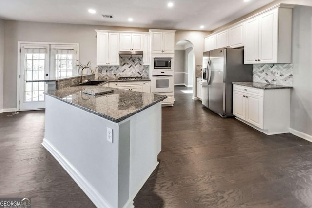 kitchen with stainless steel appliances, white cabinetry, sink, and kitchen peninsula