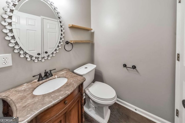 bathroom featuring vanity, hardwood / wood-style floors, and toilet