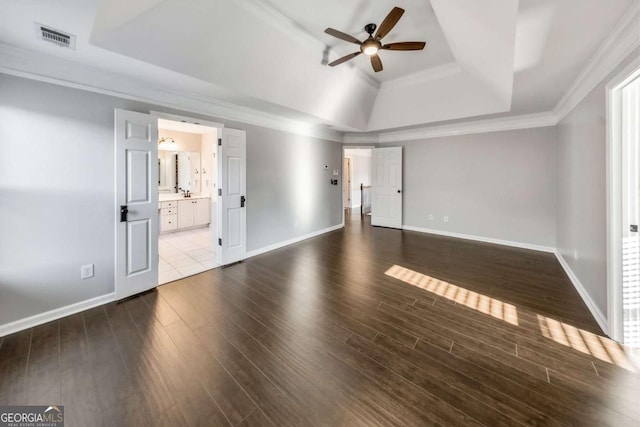 interior space with crown molding, a tray ceiling, wood-type flooring, and ceiling fan