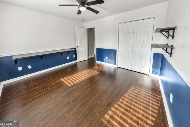 unfurnished bedroom with ceiling fan, dark hardwood / wood-style flooring, and a closet