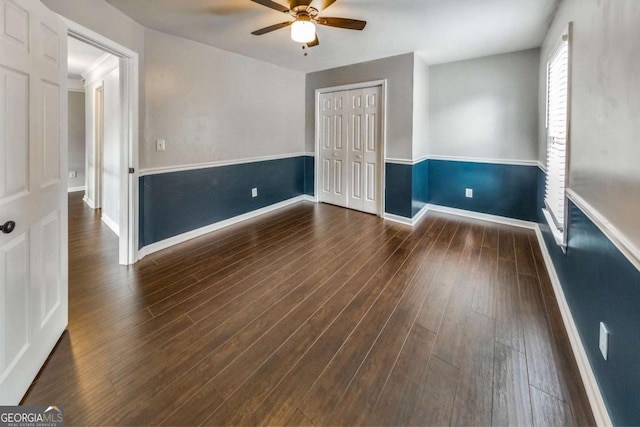 spare room with dark hardwood / wood-style flooring and ceiling fan