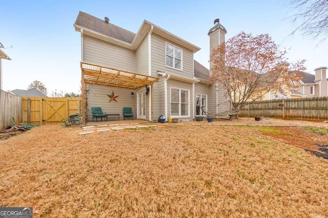 rear view of house with a pergola, a patio area, and a lawn