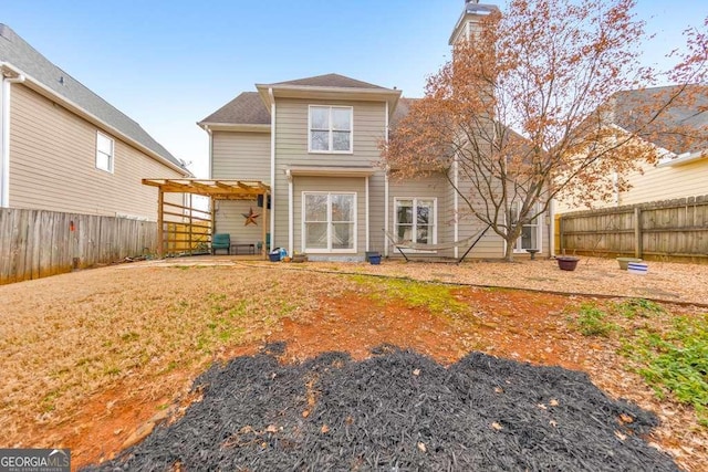 rear view of property with a pergola