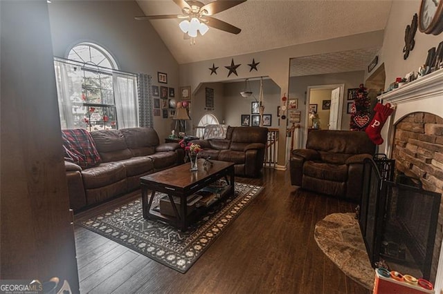 living room featuring ceiling fan, a textured ceiling, and dark hardwood / wood-style flooring